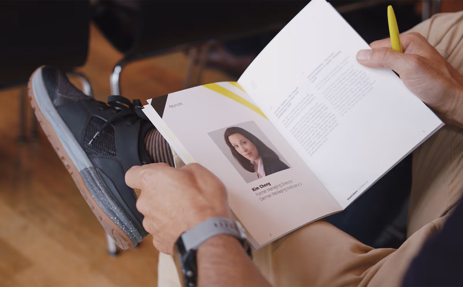 Person hält Buch mit Porträt und Text über Kim Cheng, ehemalige Geschäftsführerin des German Packaging Institute.