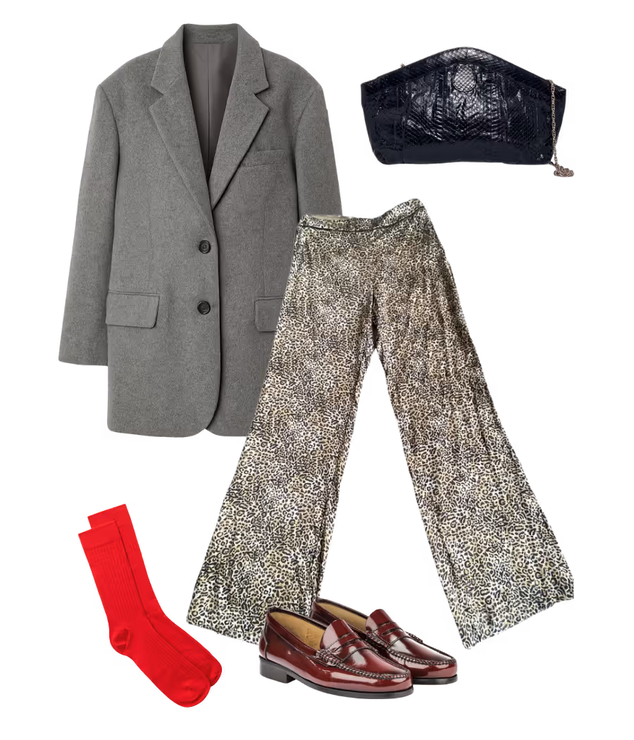 Leopard-print trousers styled with grey oversized blazer, red socks, and brown loafers for an eclectic contrast look.