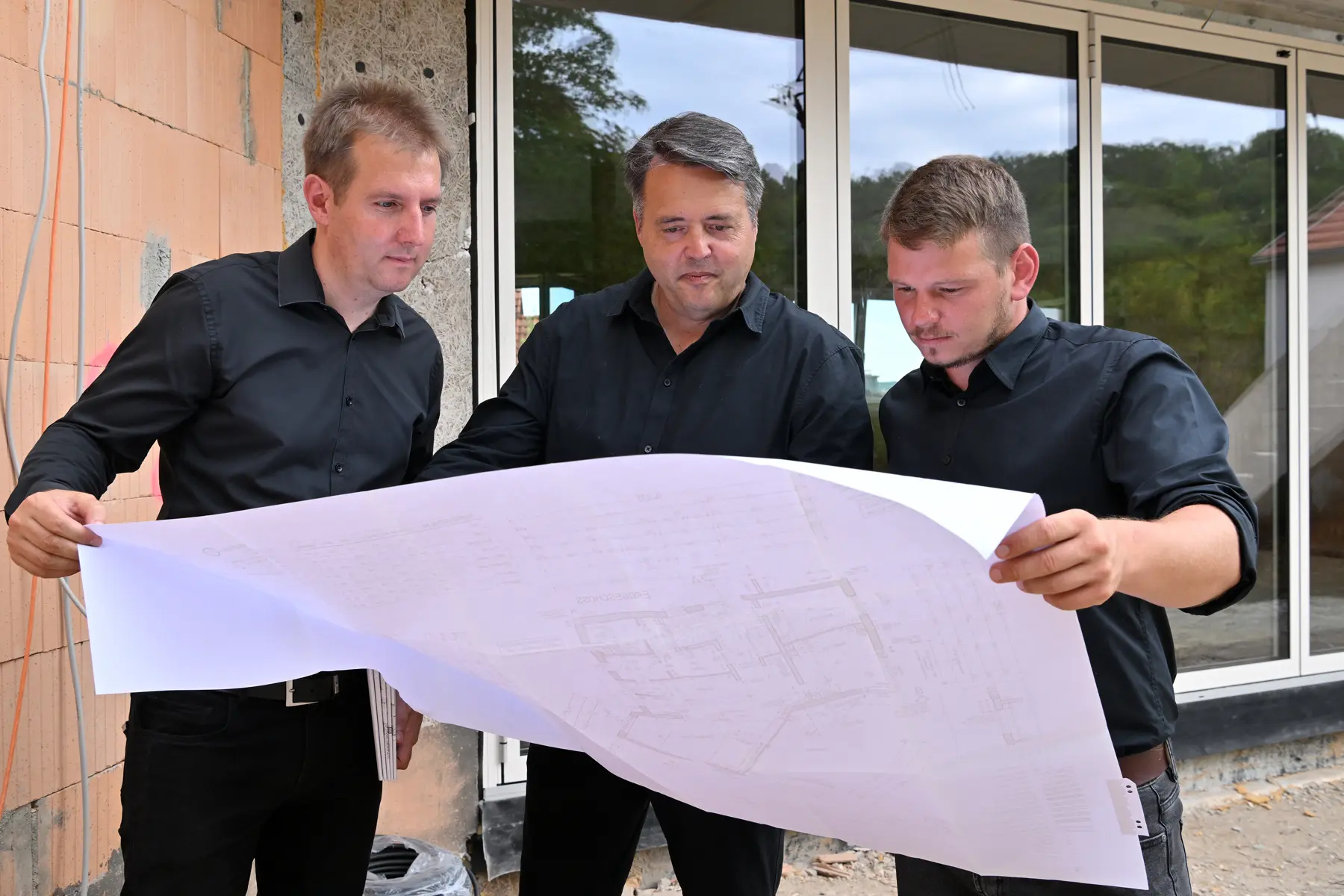 Frankenhaus Mitarbeiter Roland Schicker und Kollegen gucken in einen Bauplan
