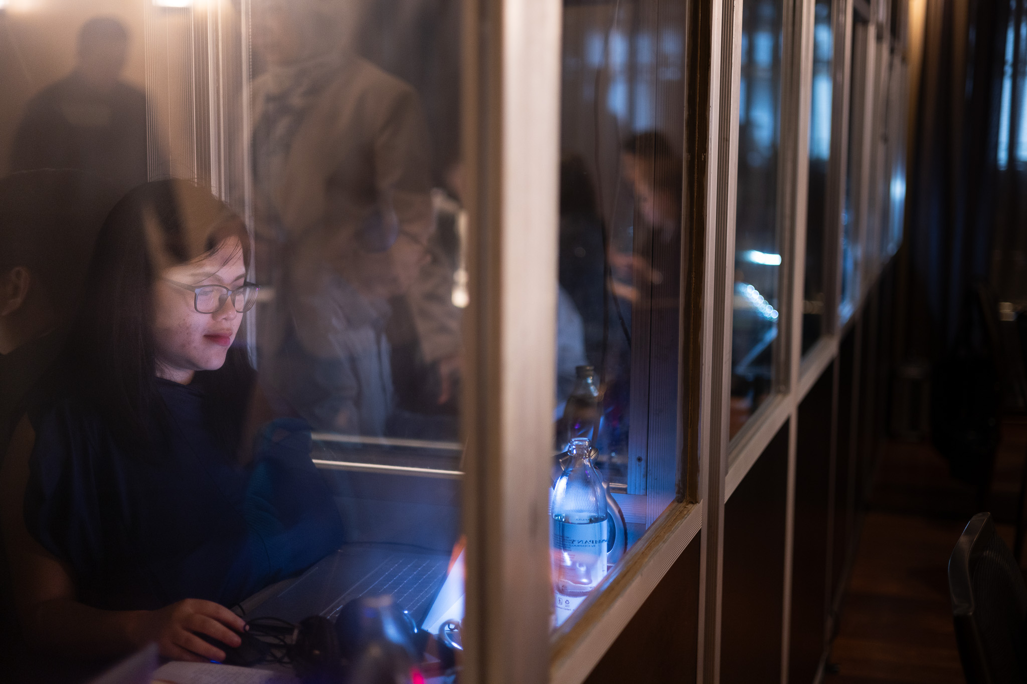 Interpreter working at a laptop inside a booth