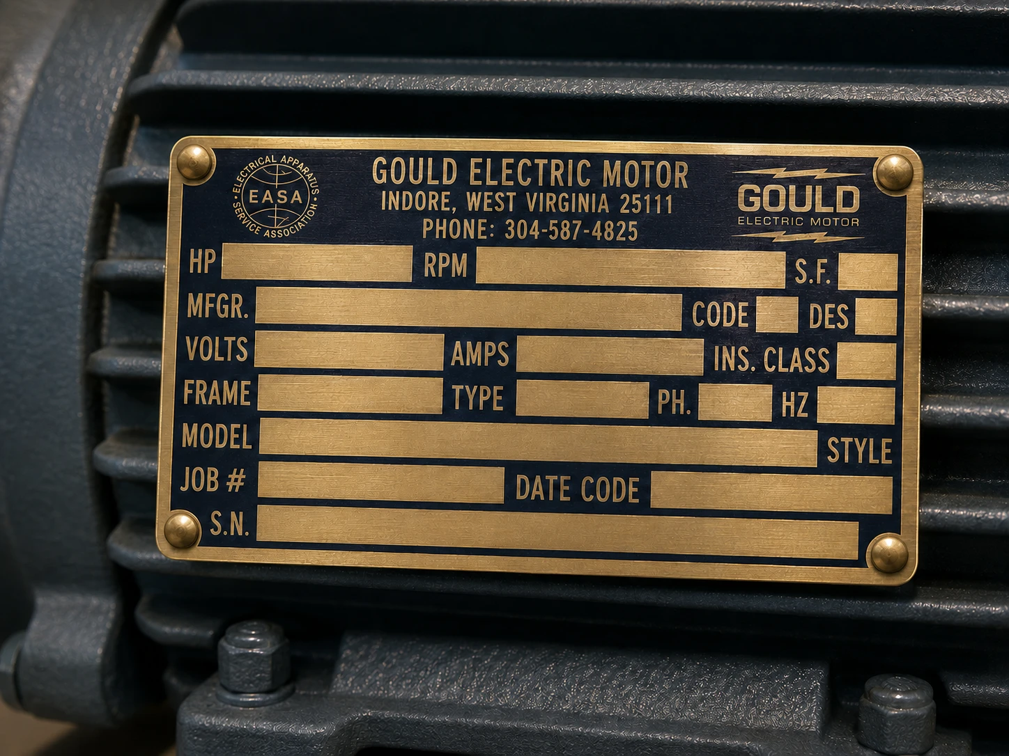 Brass motor data nameplate mounted on the frame of an industrial electric motor for power transmission.