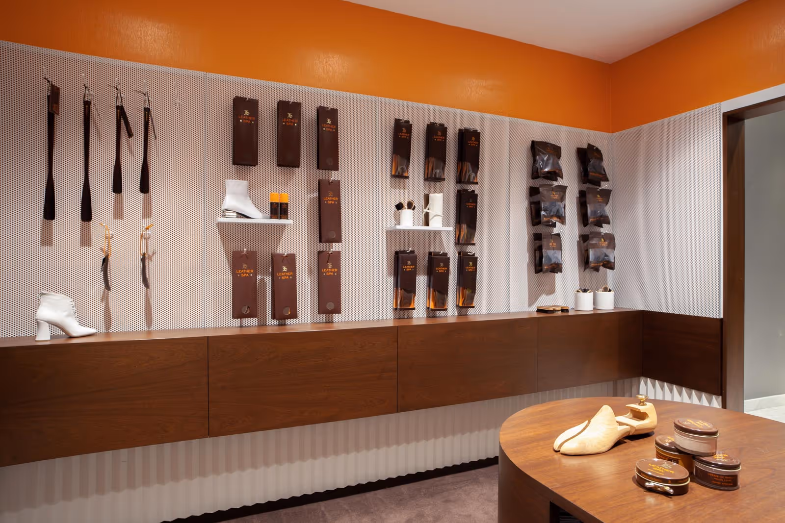 Architectural view of Leather SPA interior at Saks, showing coordinated shelving grids, integrated lighting, minimalist palette, and premium retail detailing.