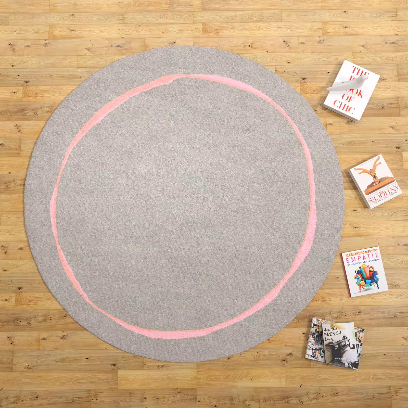 Round gray rug with a single imperfect pink circular line across the center in room settings