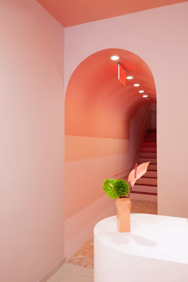 Hair Salon interior design. Arched entrance with bluch color gradient and flowers. Young and colorful design