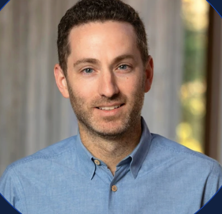 Headshot of Joshua Lambert in blue shirt.