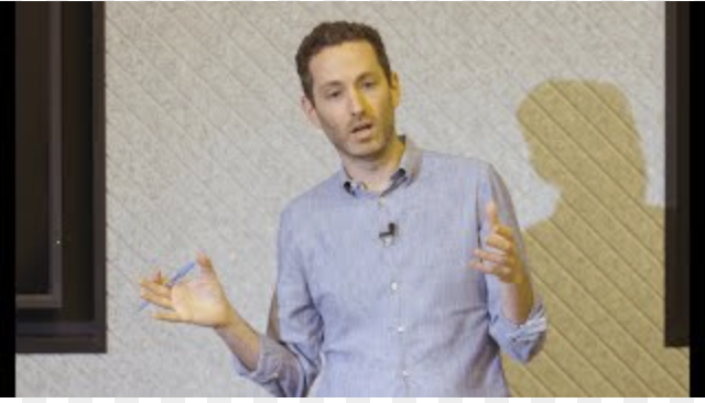 Joshua Lamber presenting in front of audience.