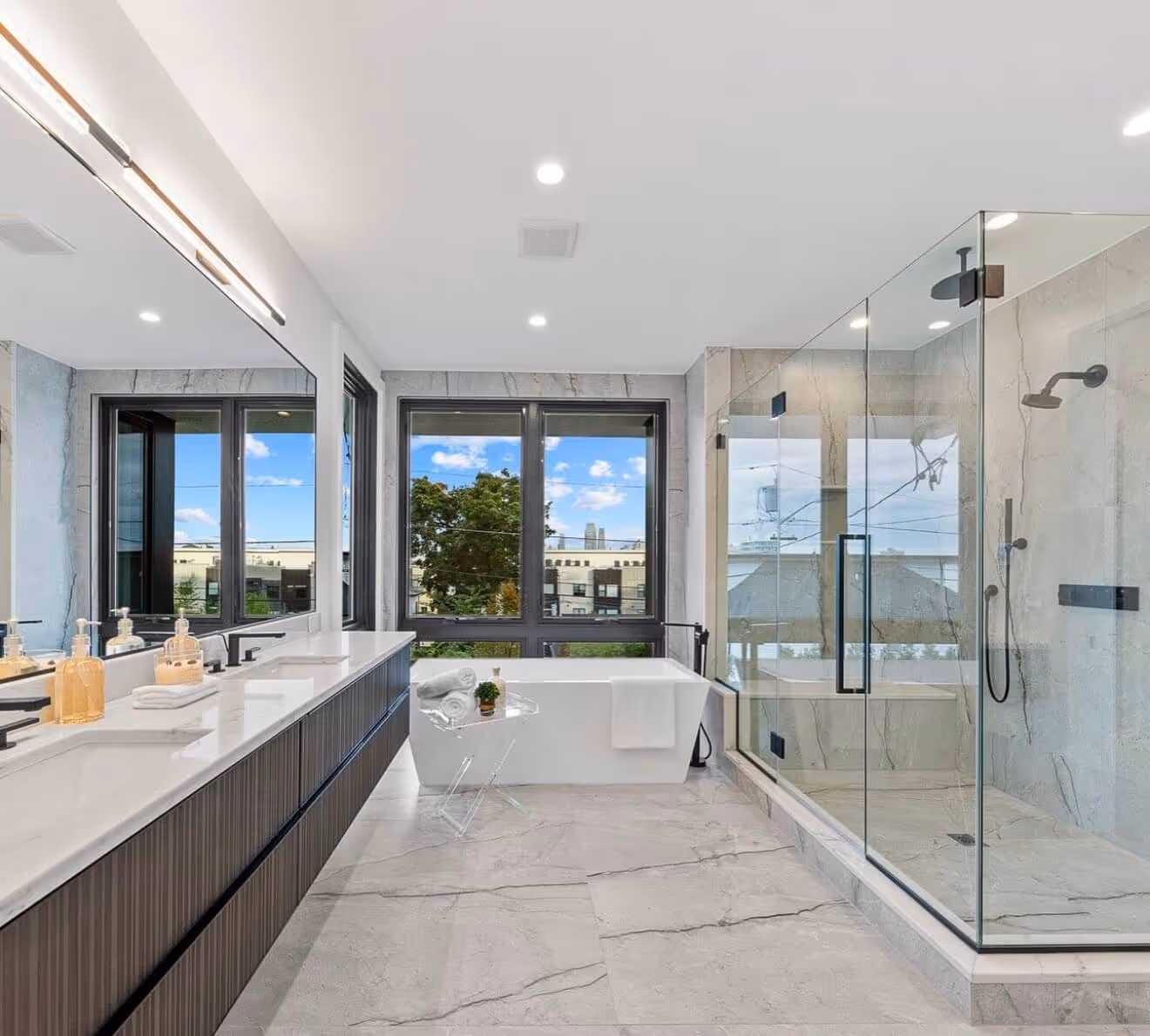 Luxury bathroom with a long double vanity, shower, free standing tub installed by us.