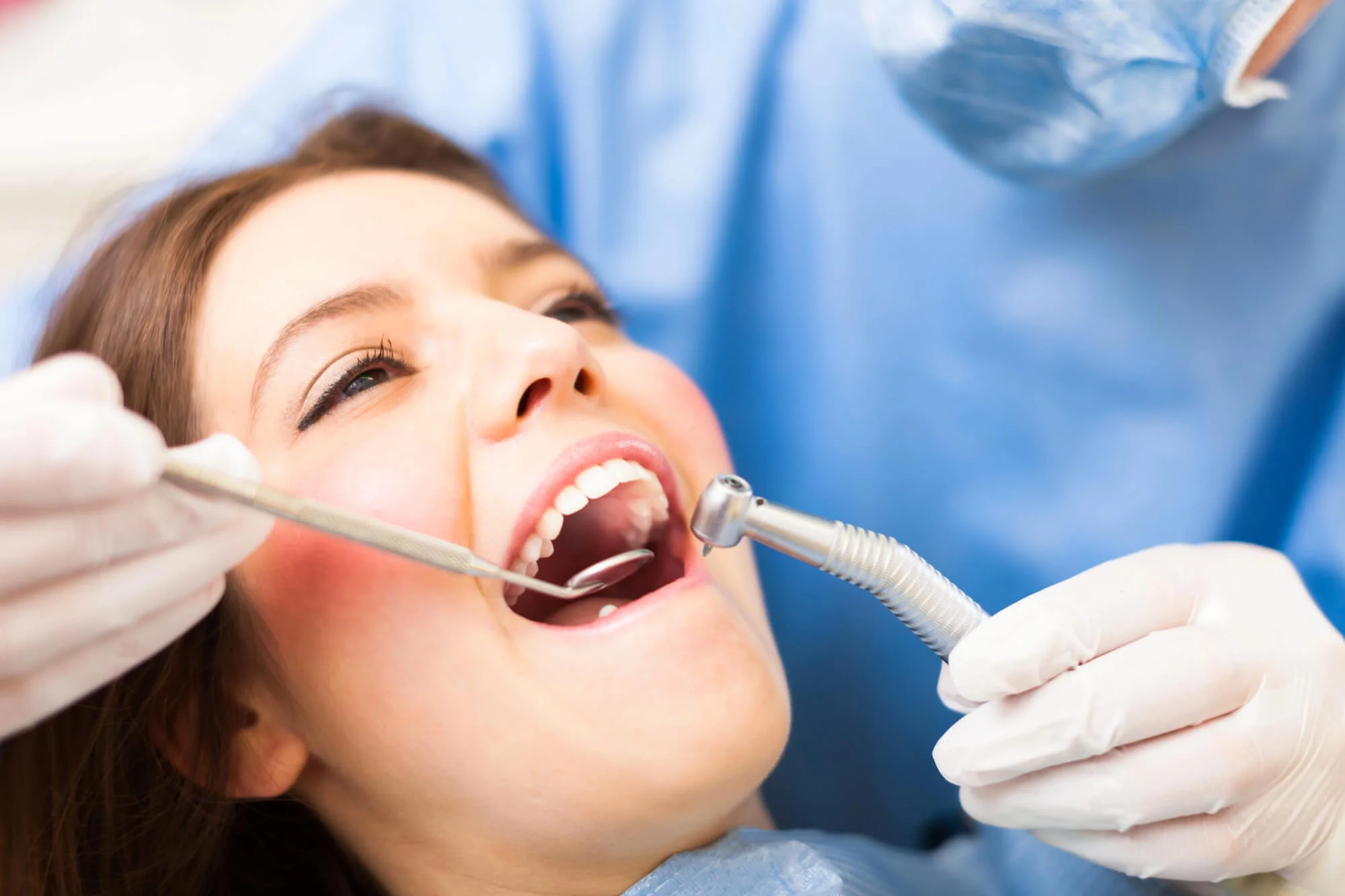 Female patient receiving dental treatment with drill – dental crowns near you