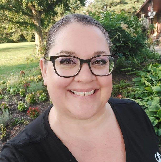 Person who is wearing glasses and smiling. 