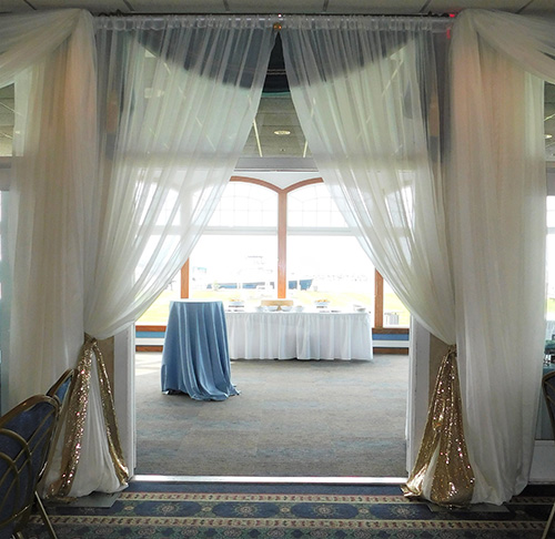Sandusky Yacht Club door draping in ivory, covering green window curtains. 