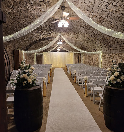 Gideon Owen cellar ceremony with aisle runner and fairy light backdrop. 