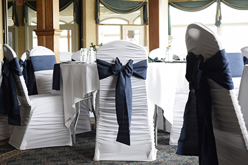 White chair cover with navy sash.