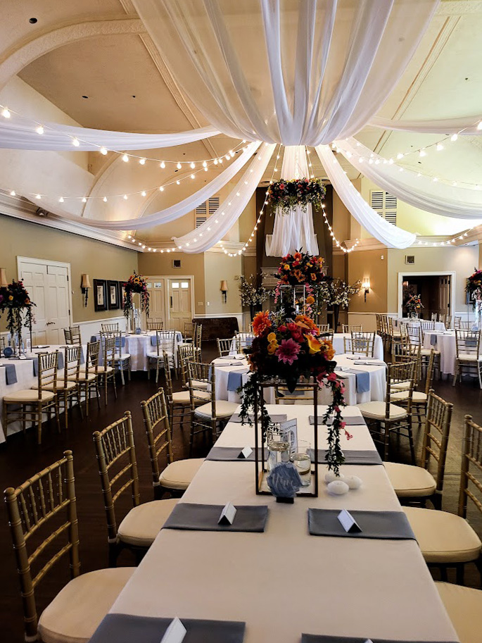 Fall florals, white fabric, and bistro lights on the ceiling. 