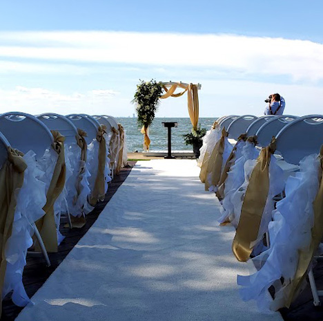 White aisle runner for ceremony at beach.