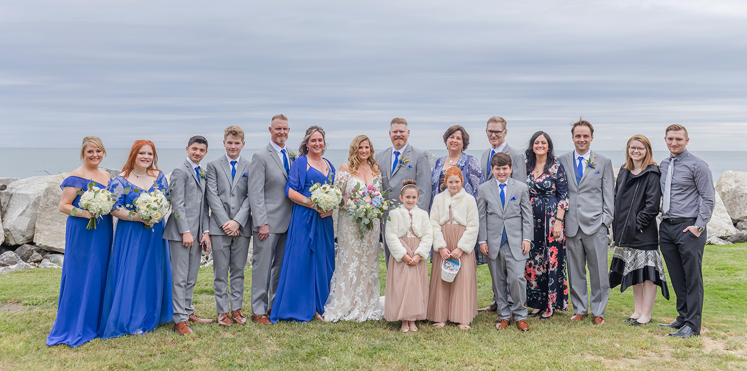 Bridal party in grey and royal blue by the beach.
