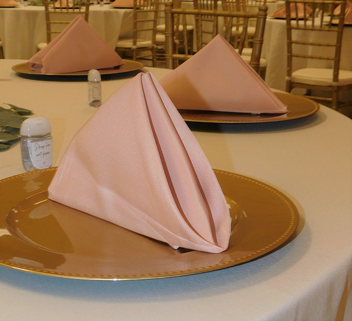Dusty rose napkin on gold charger.