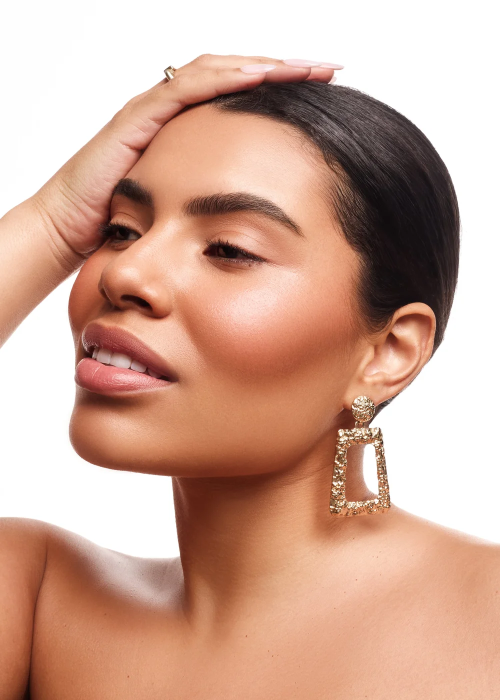 Lifestyle photo of model with beauty product in studio