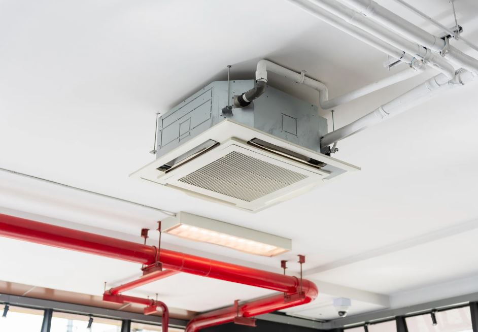 Ceiling cassette AC unit with exposed pipes.