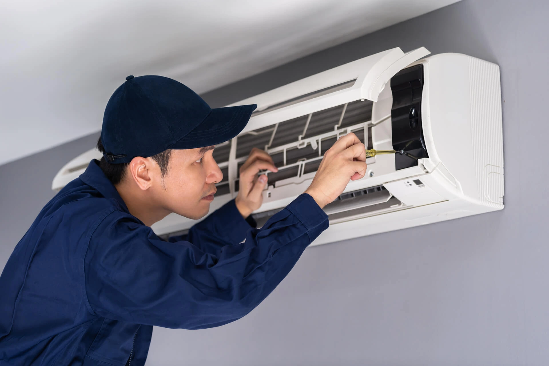 hvac technician fixing an ac