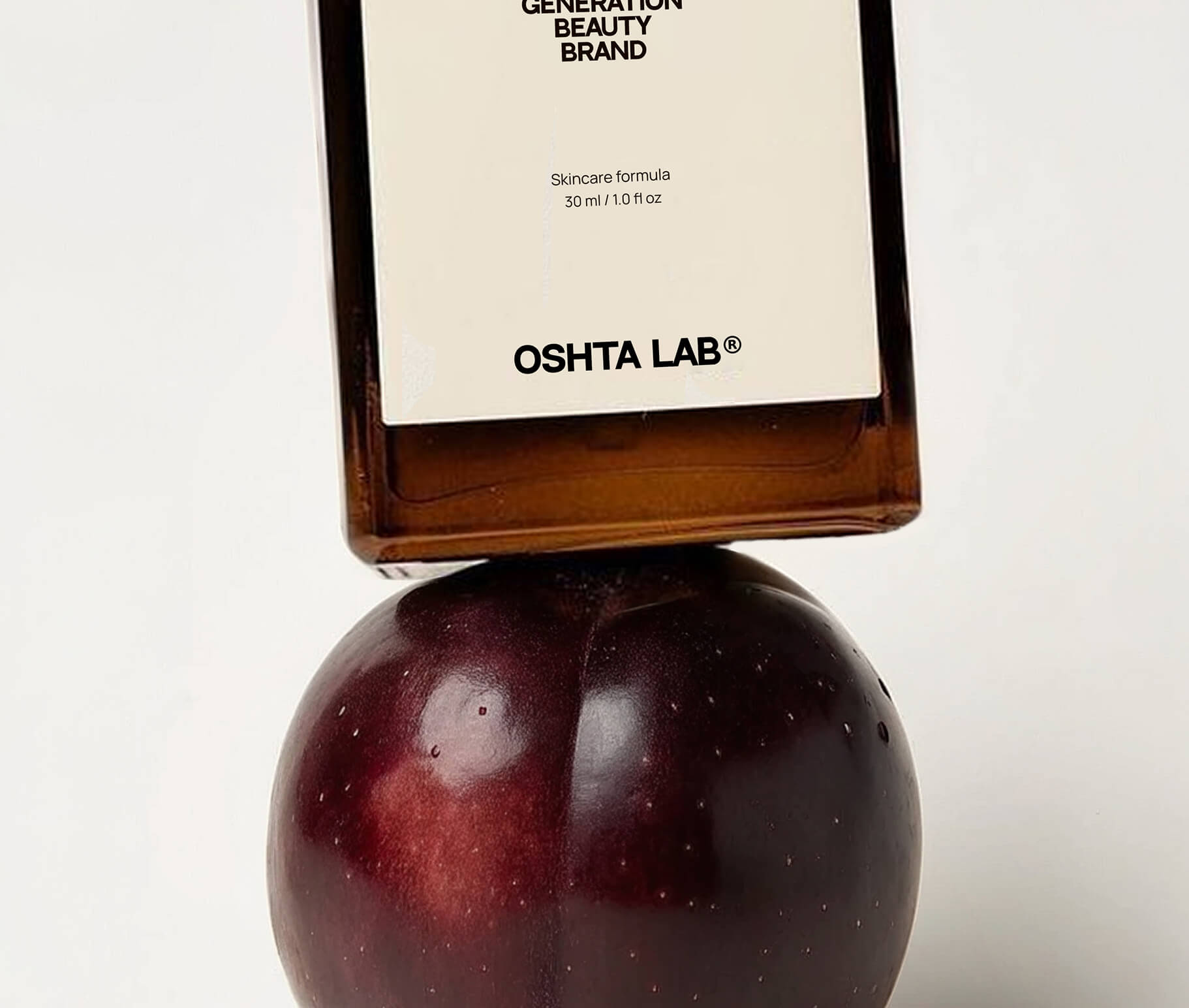 A bottle of OSHTA LAB standing on a plum
