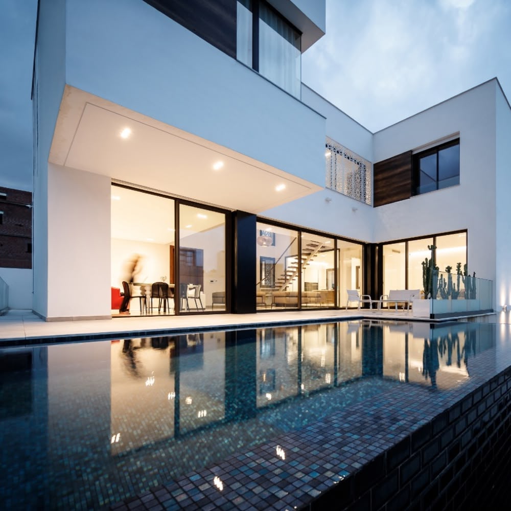 Détail d'une baie vitrée coulissante TPR Aluminium dans un salon lumineux, illustrant la finesse des profilés et la maximisation de la lumière naturelle