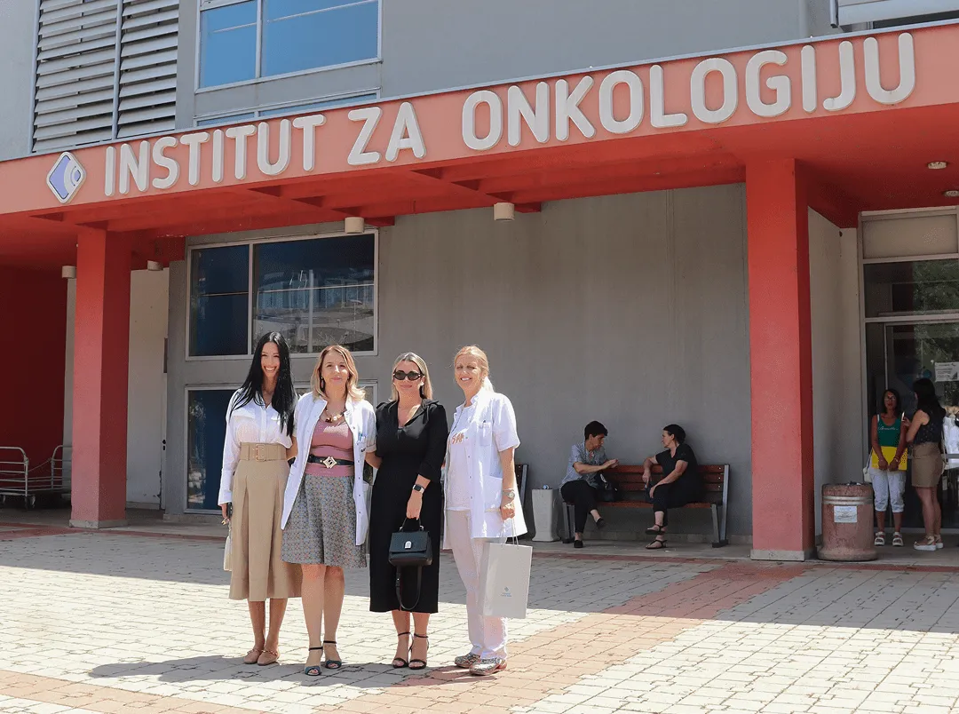 Četiri žene stoje ispred zgrade Instituta za onkologiju na suncu.