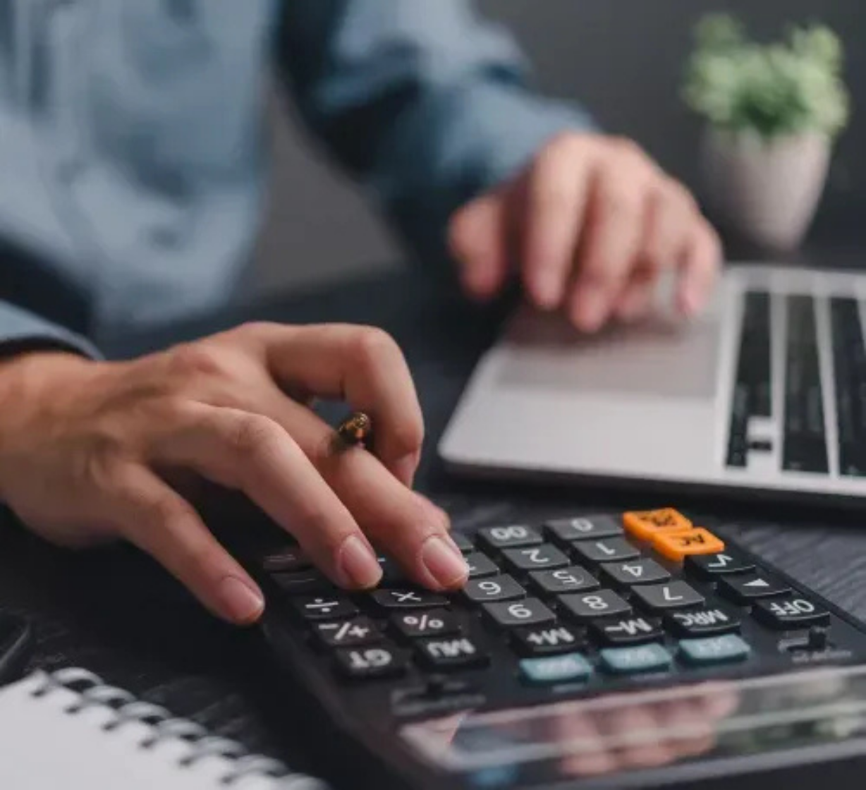 Dłoń wystukująca dane na kalkulatorze – kontrola finansów i poprawa BIK