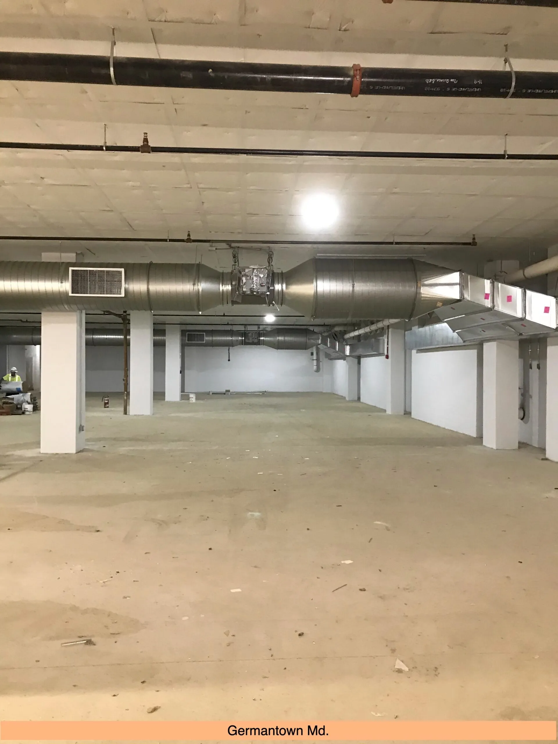Industrial basement with large metal ventilation ducts and concrete floor