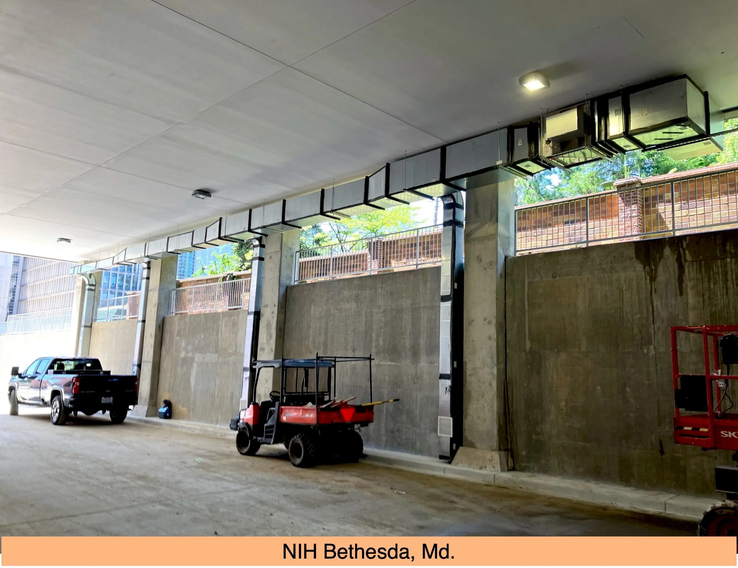 Parking area with truck, utility vehicle, and concrete walls at NIH Bethesda