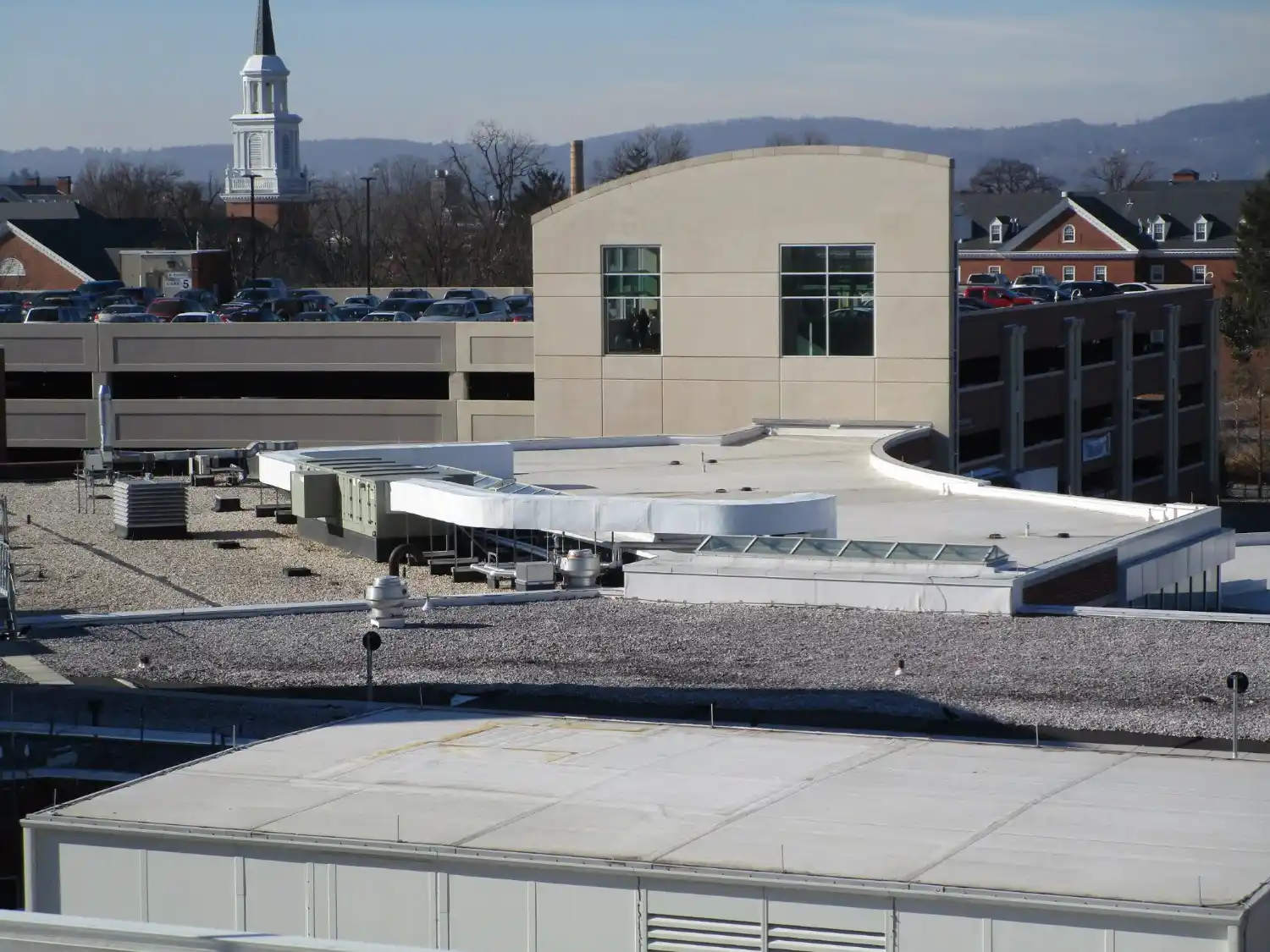 A modern white building next to a submarine.