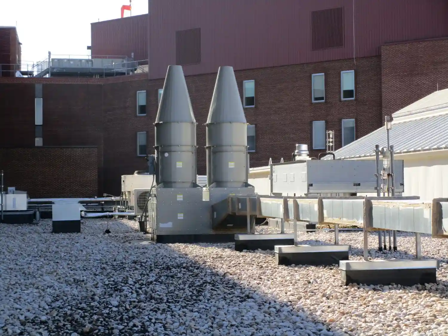 A building rooftop with two ventilation pipes.