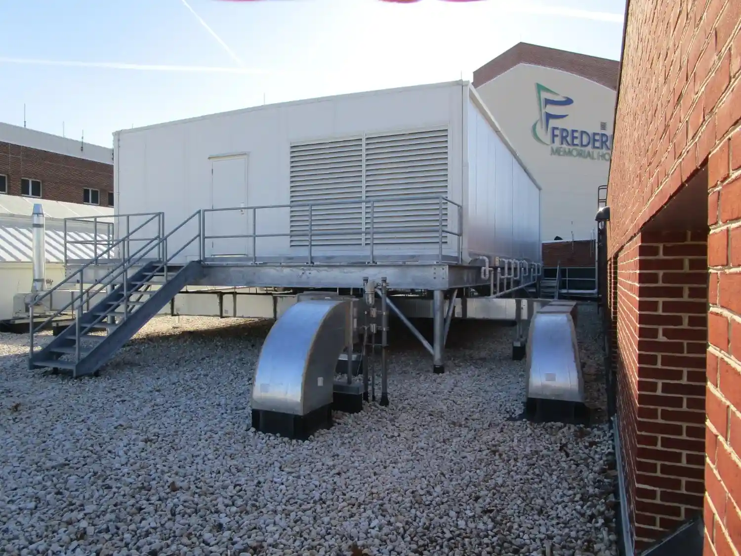 A portable building on a gravel lot.