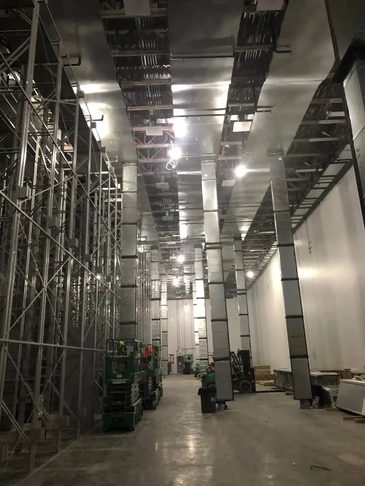 A long industrial room with a high ceiling and large ventilation ducts.