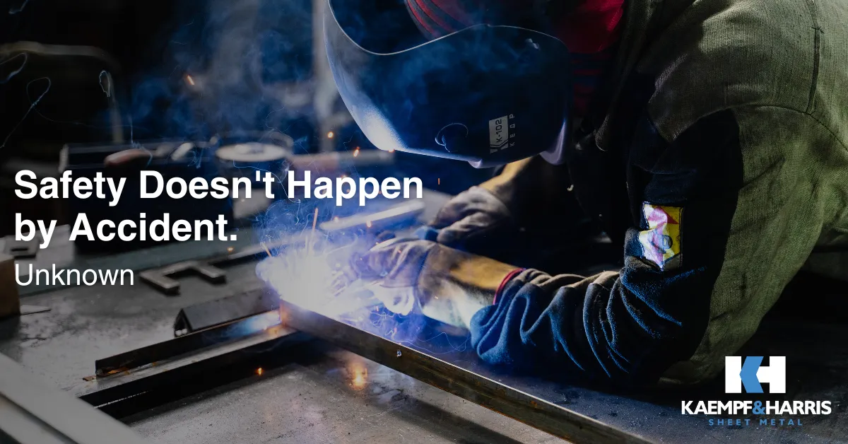 Welder in protective gear working with blue sparks and metal