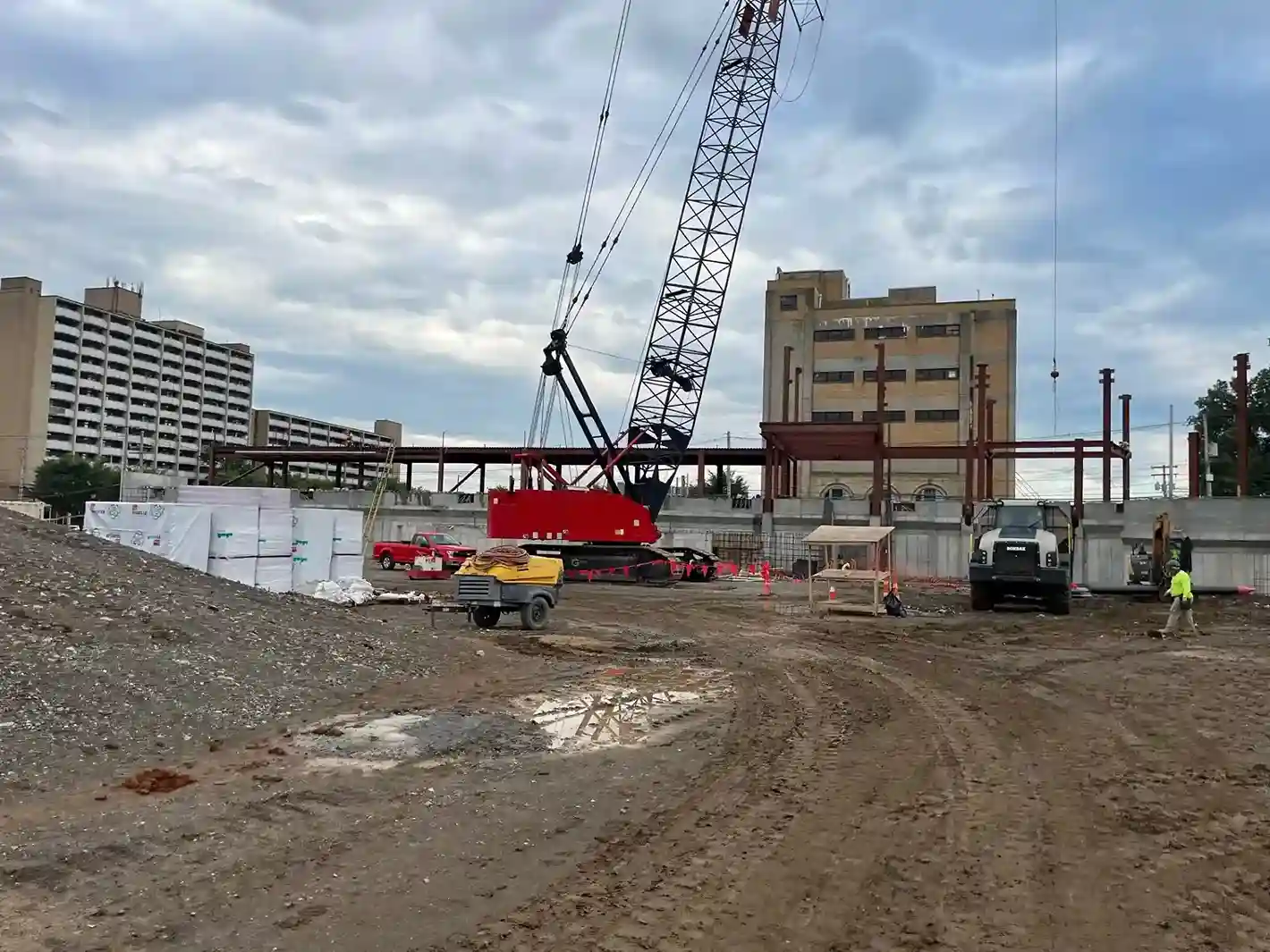 A construction site with a large crane and buildings.
