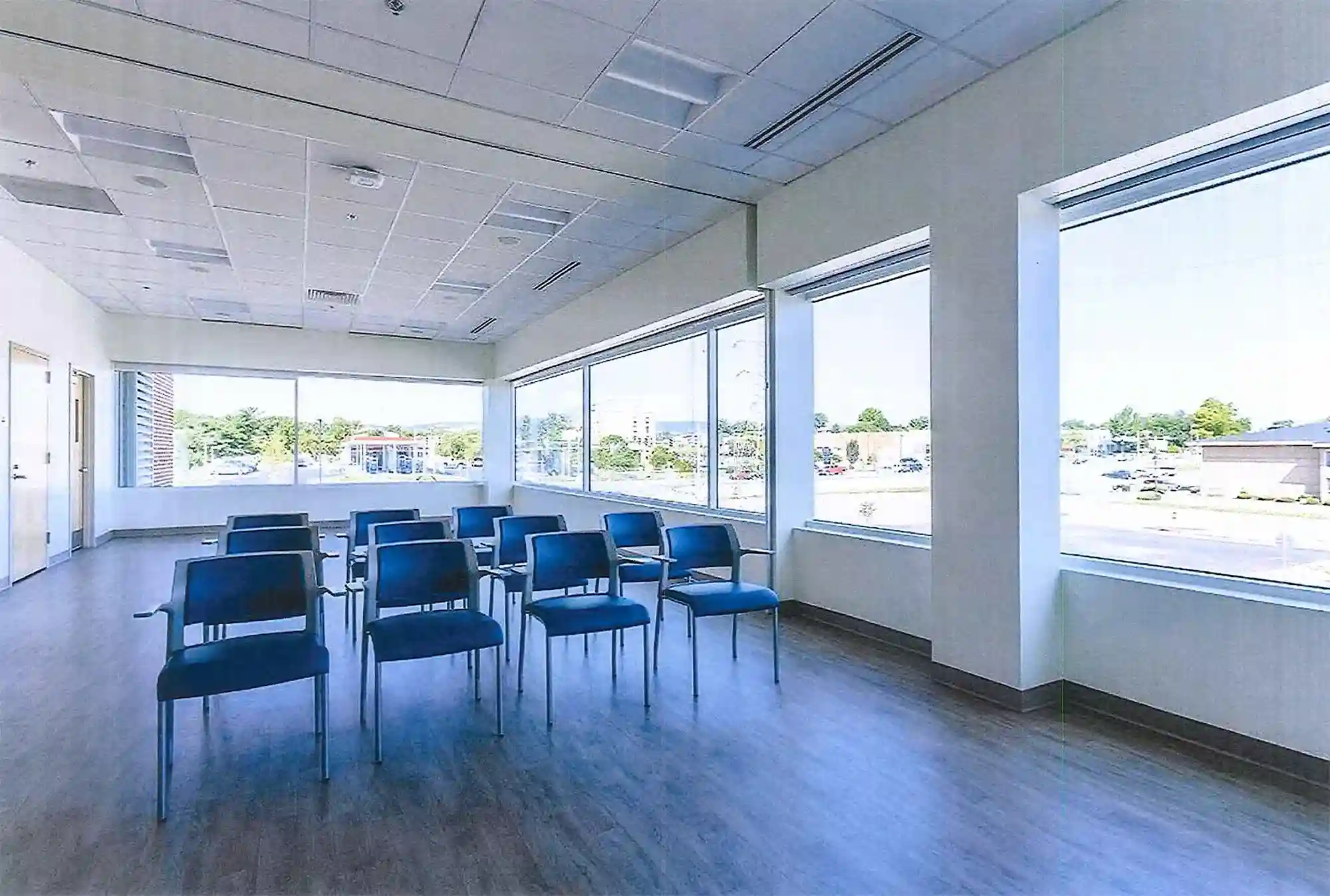 A room with large windows and blue chairs.