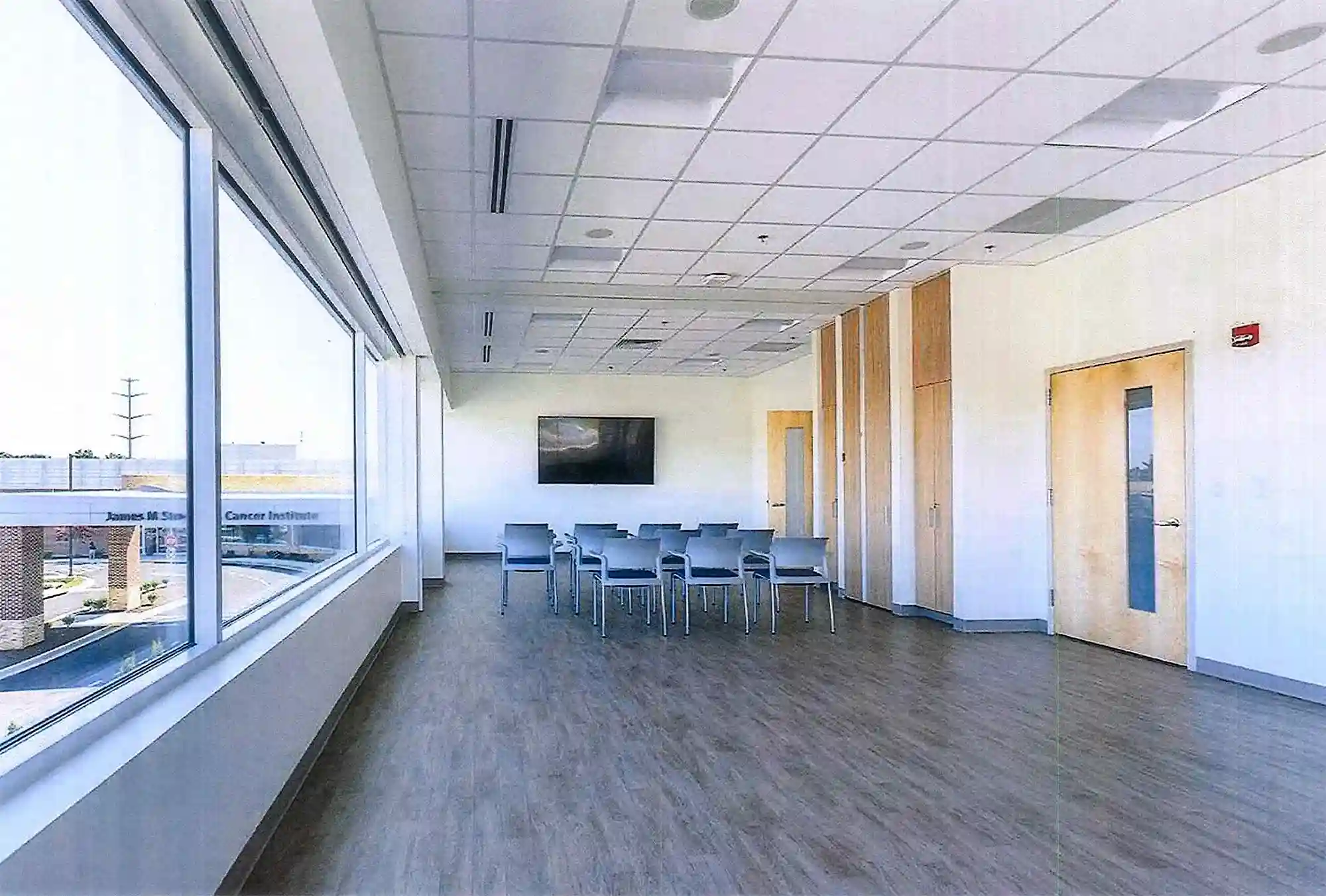 A conference room with a large window and television.