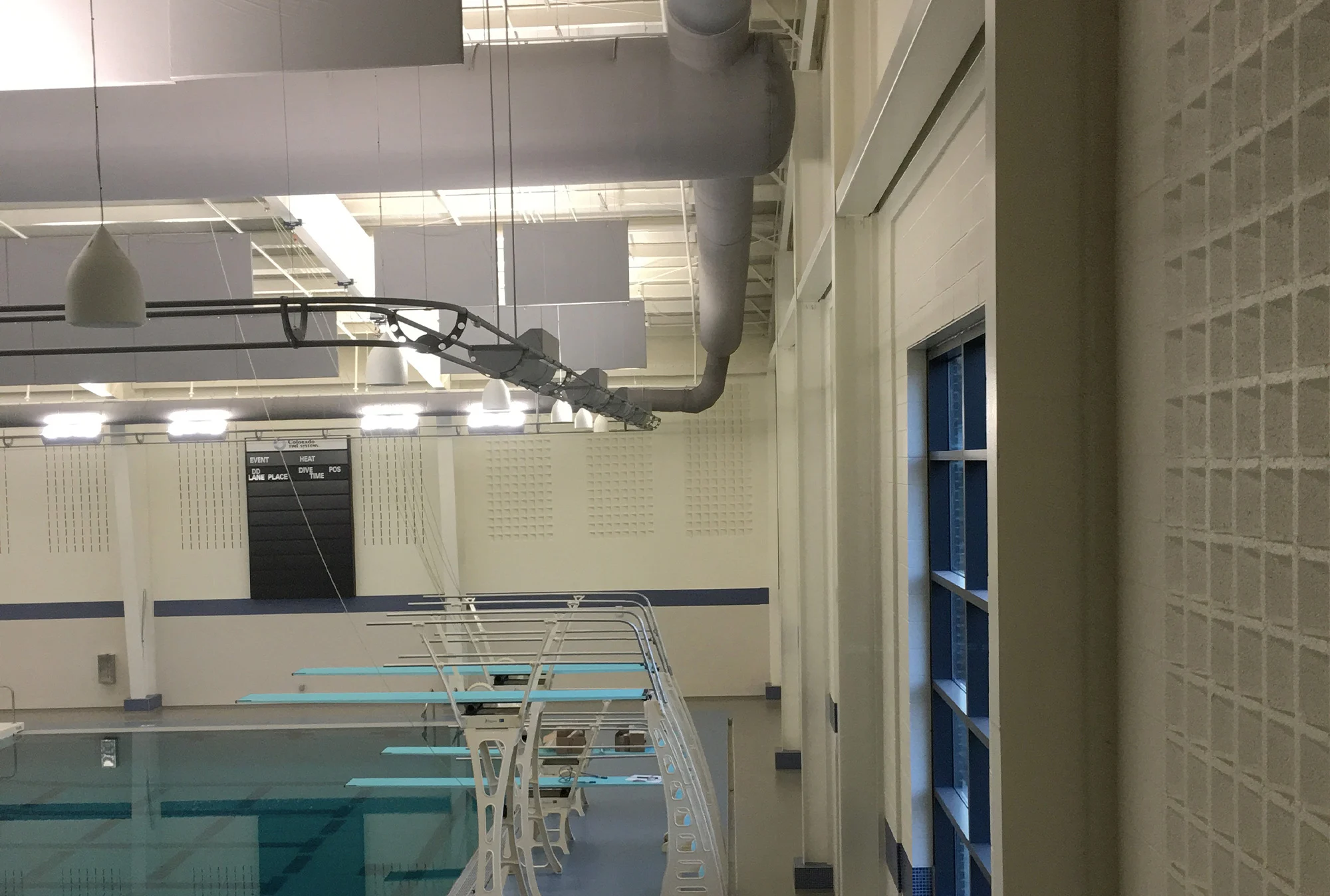A side view of a diving board in an indoor pool.