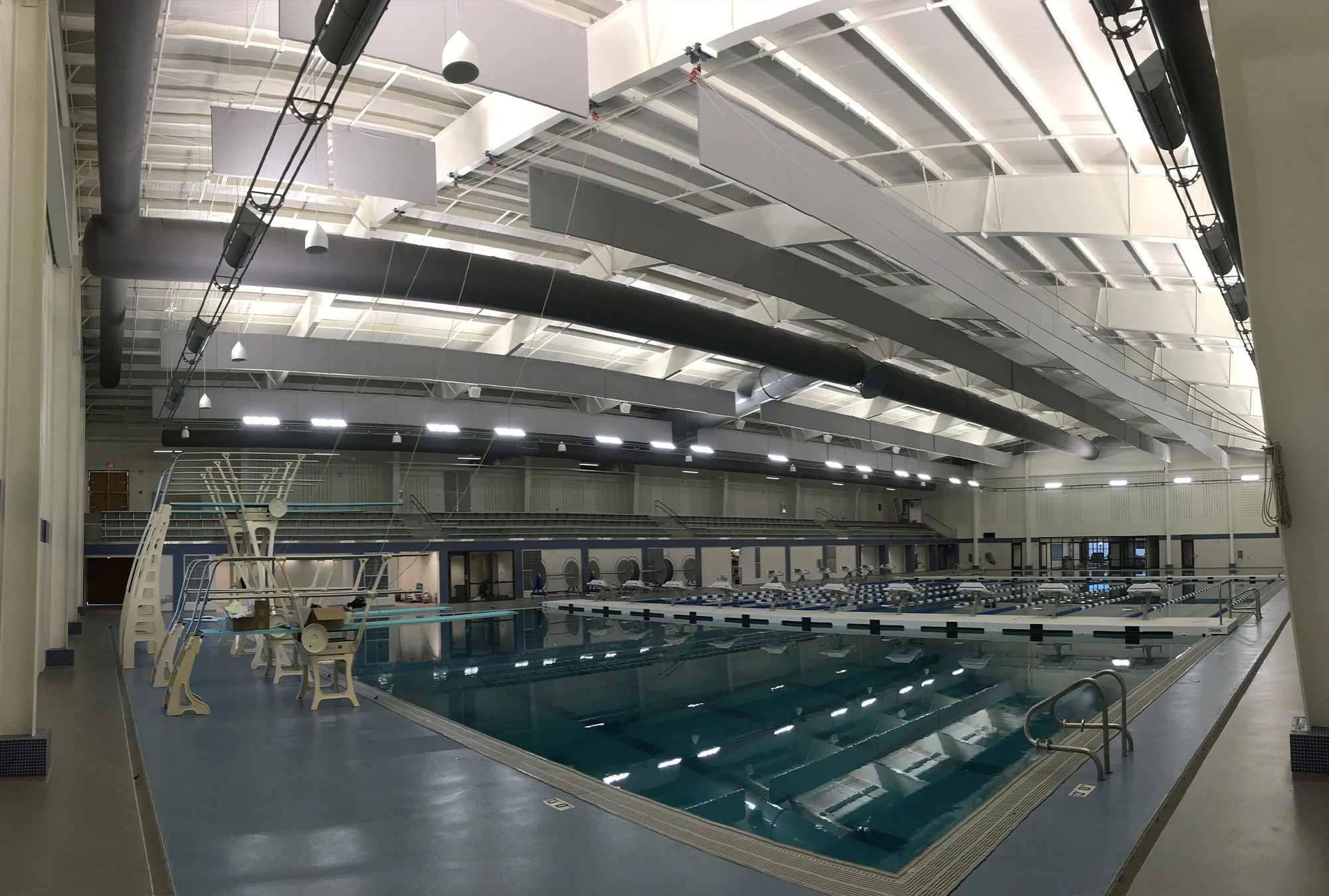 A very wide-angle view of a large indoor swimming pool.