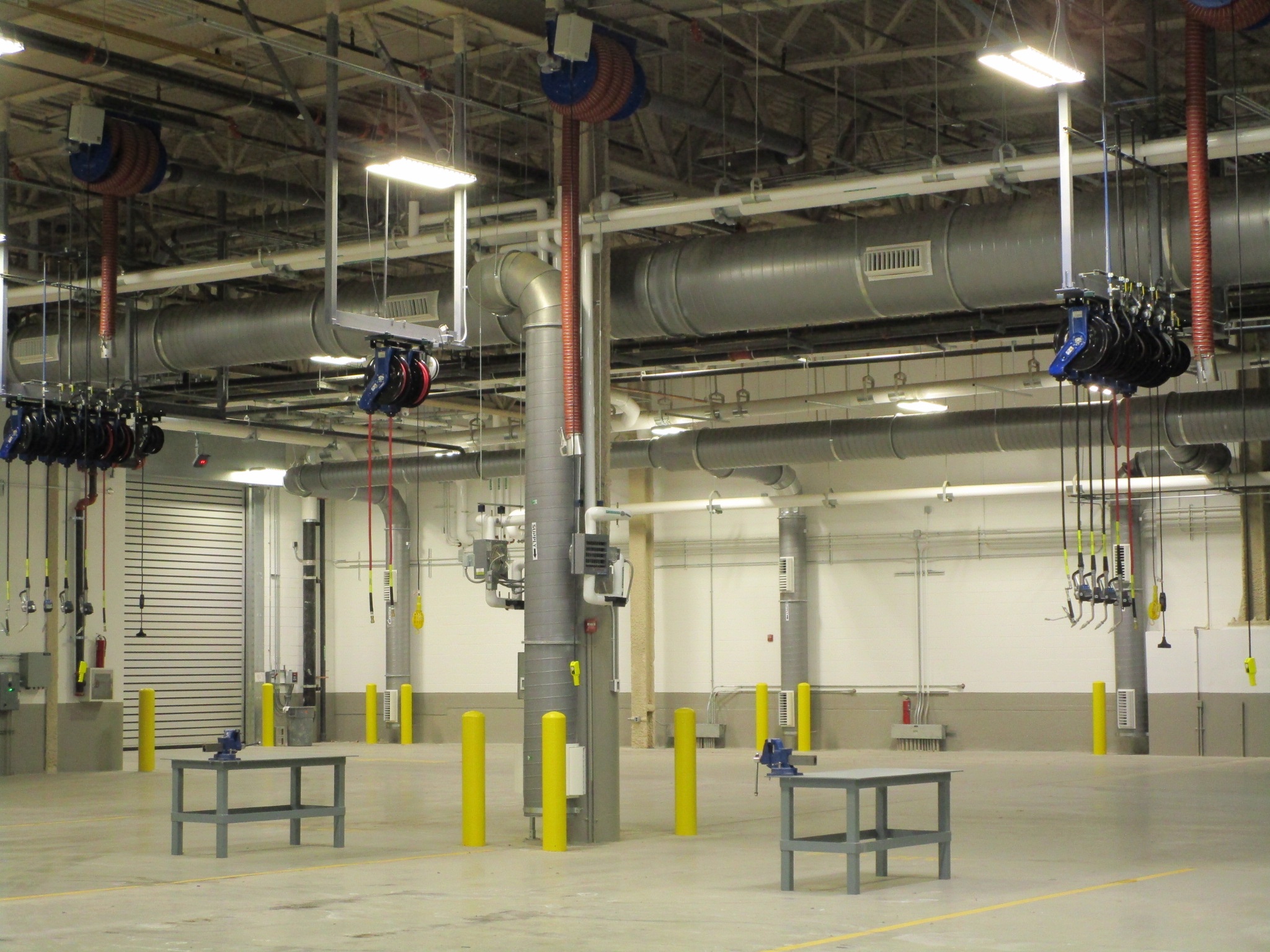 A large industrial space with high ceilings and hanging lights.