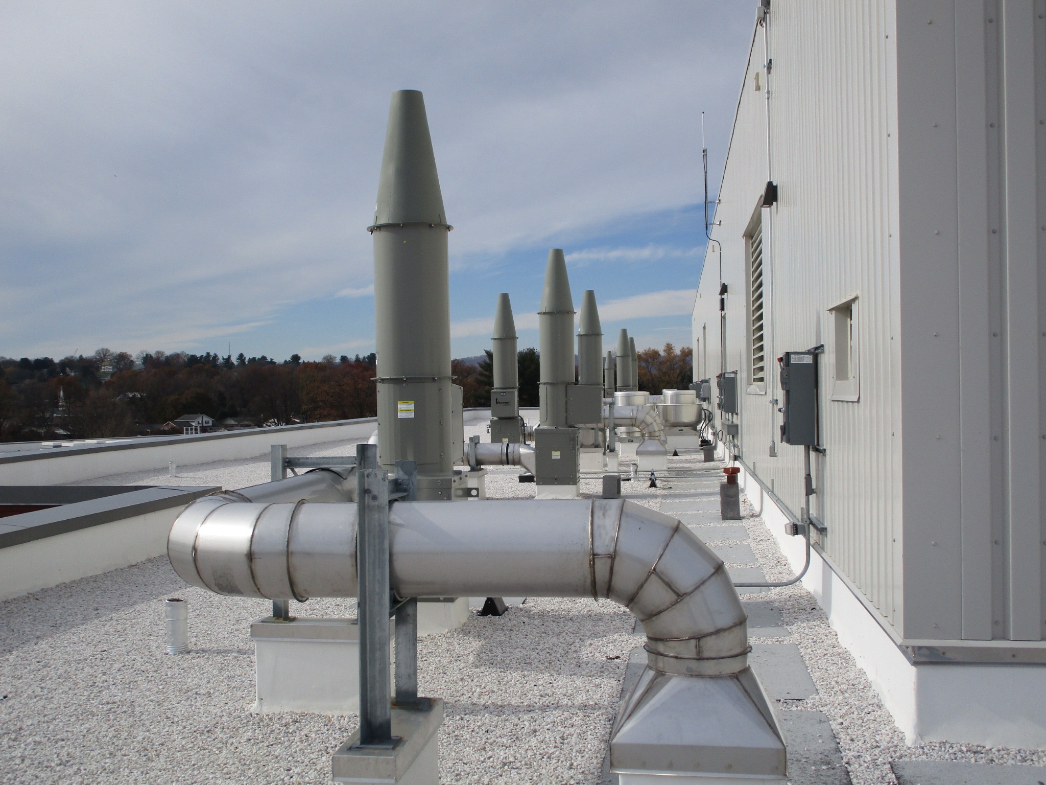 A building rooftop with multiple ventilation pipes.