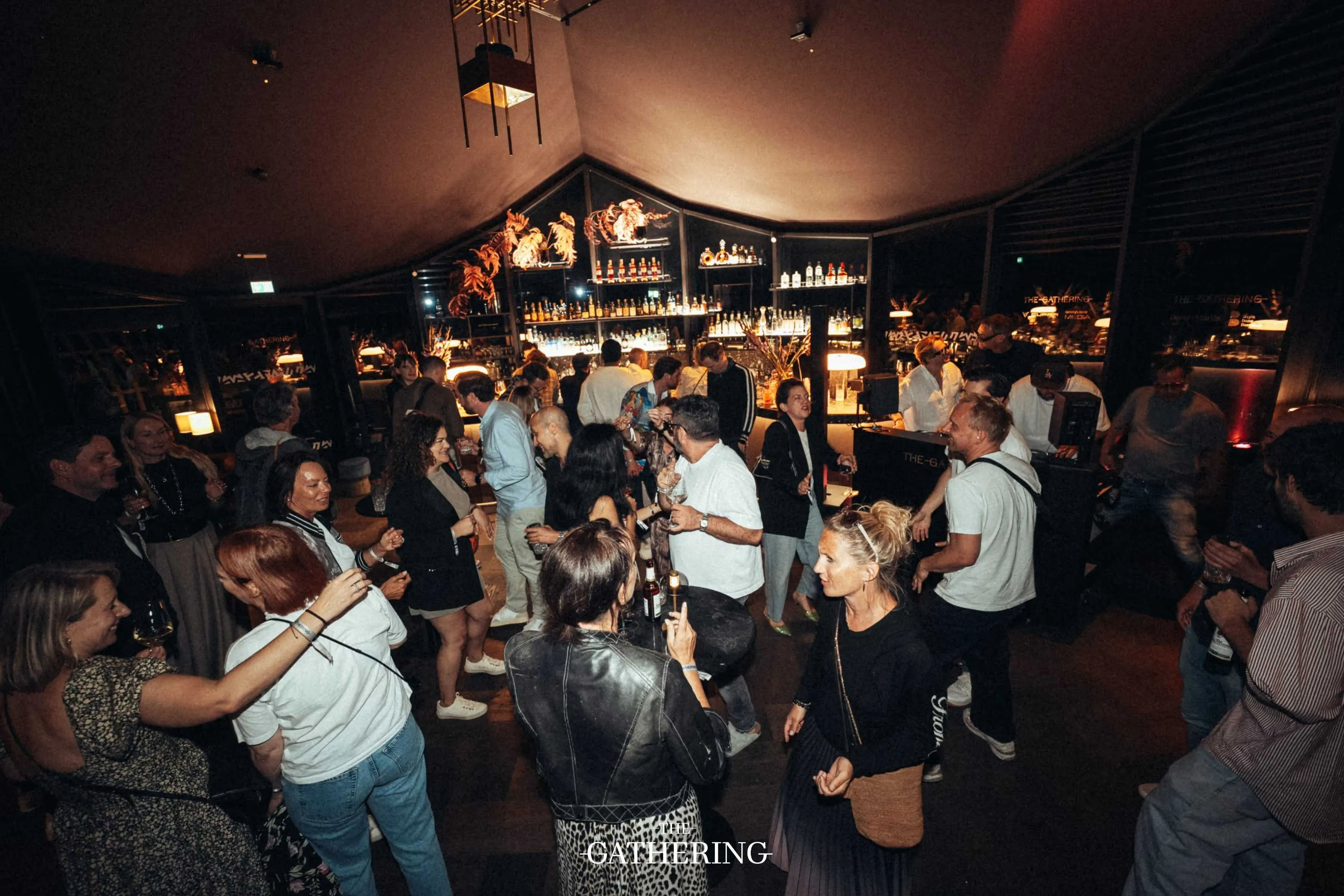 Crowd mingling with drinks at The Gathering hosted by Maison ACME