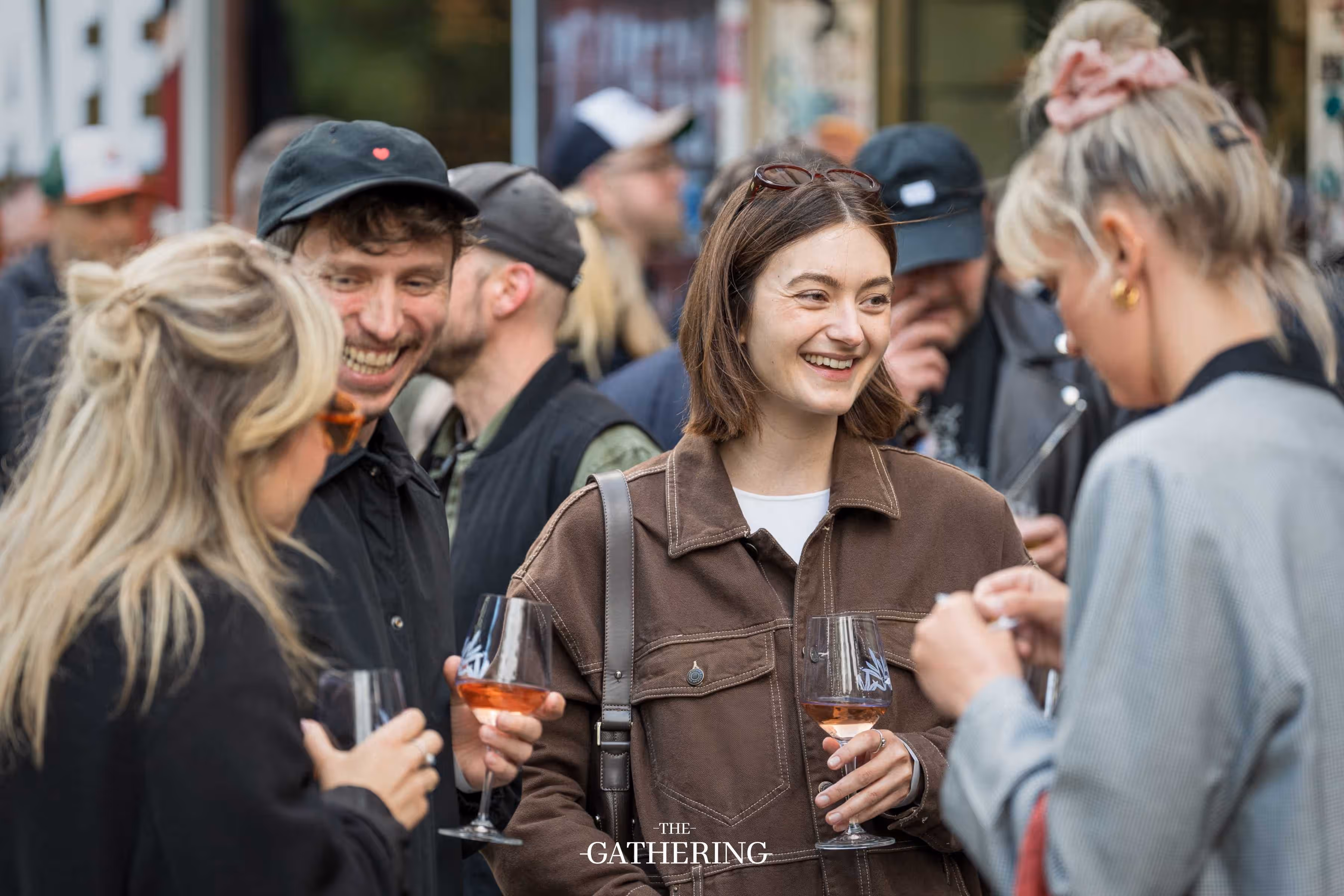 Crowd mingling around tables with drinks at The Gathering hosted by Maison ACME