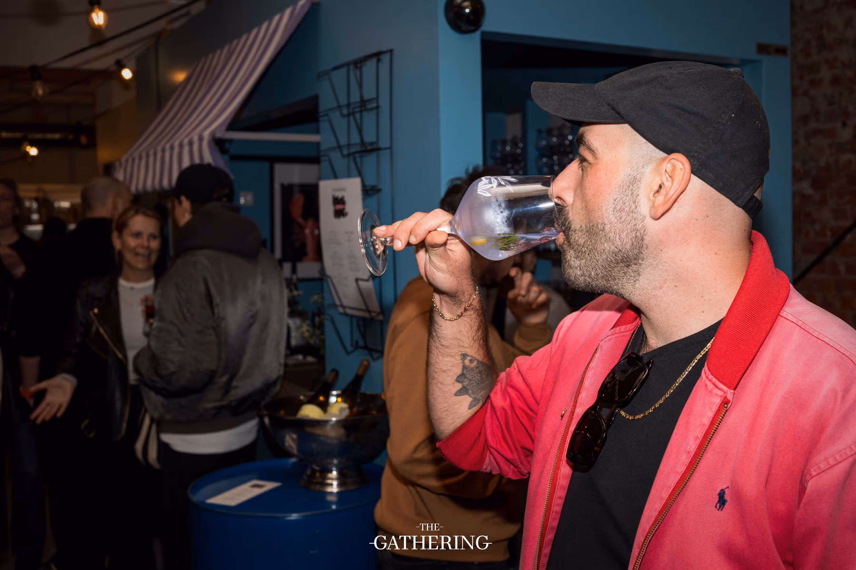 Crowd mingling around tables with drinks at The Gathering hosted by Maison ACME