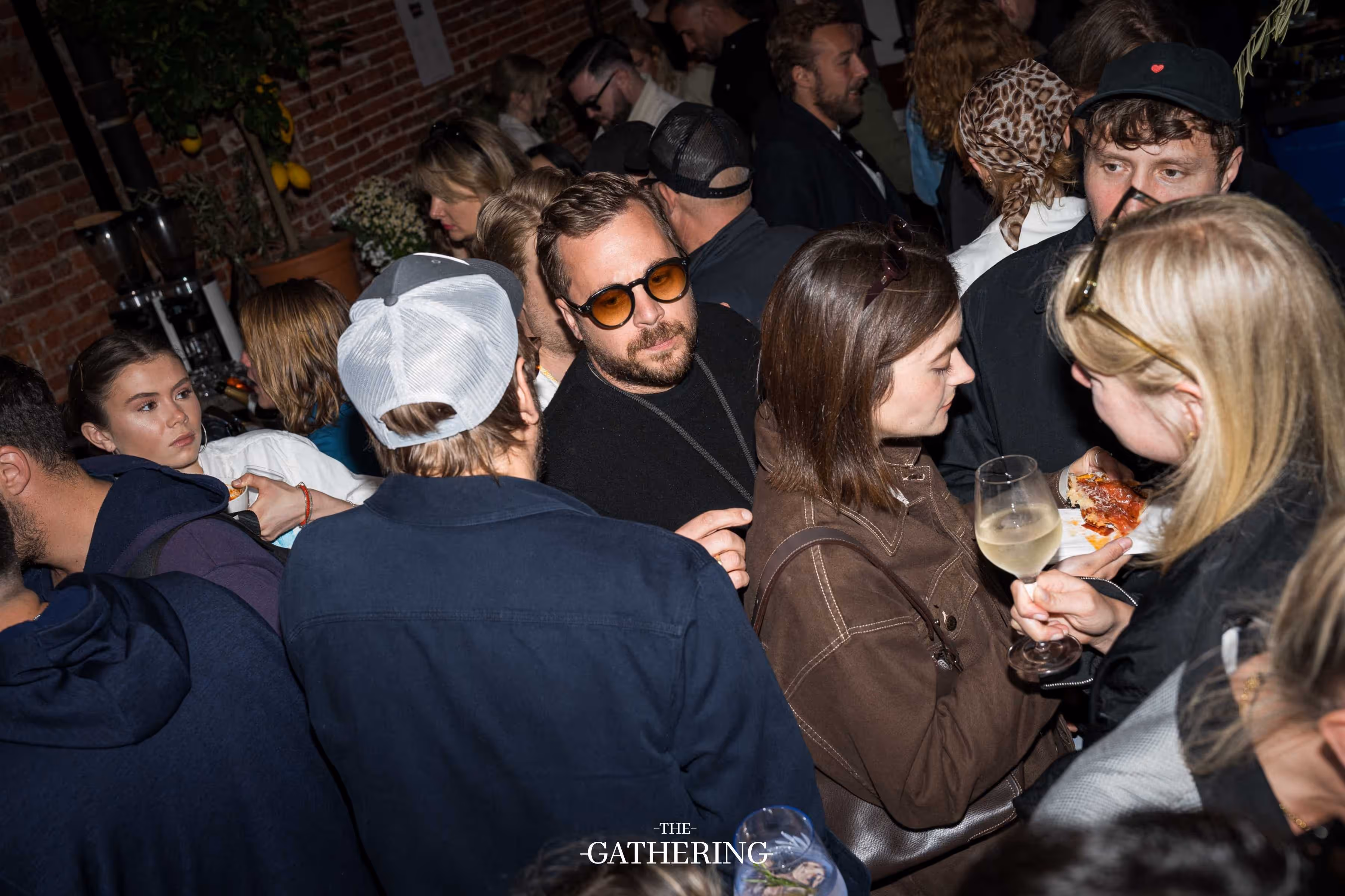Crowd mingling around tables with drinks at The Gathering hosted by Maison ACME