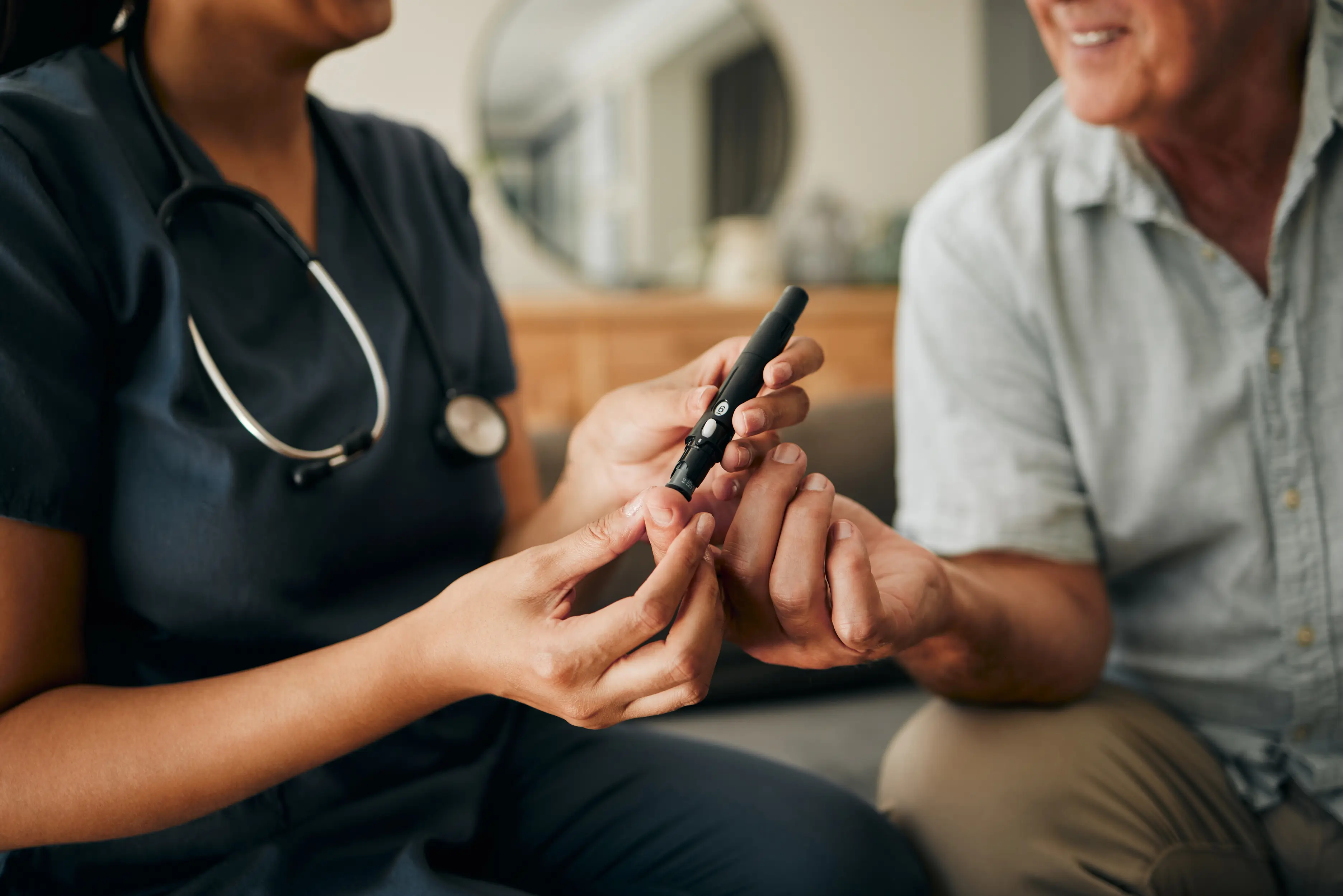 Nurse taking a finger-prick sample at home