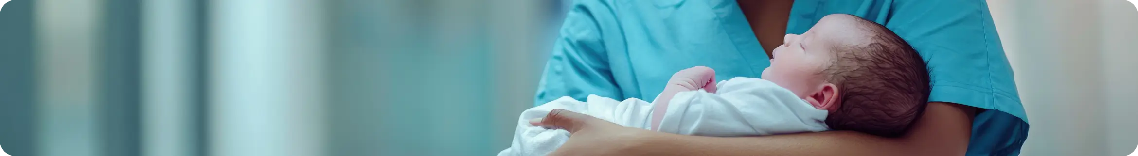 Healthcare professional holding a newborn baby in a medical setting