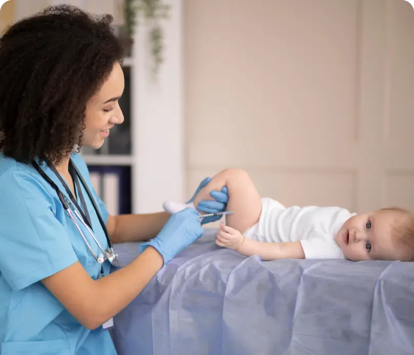 A child is lying on a couch while a nurse administers an injection in the leg
