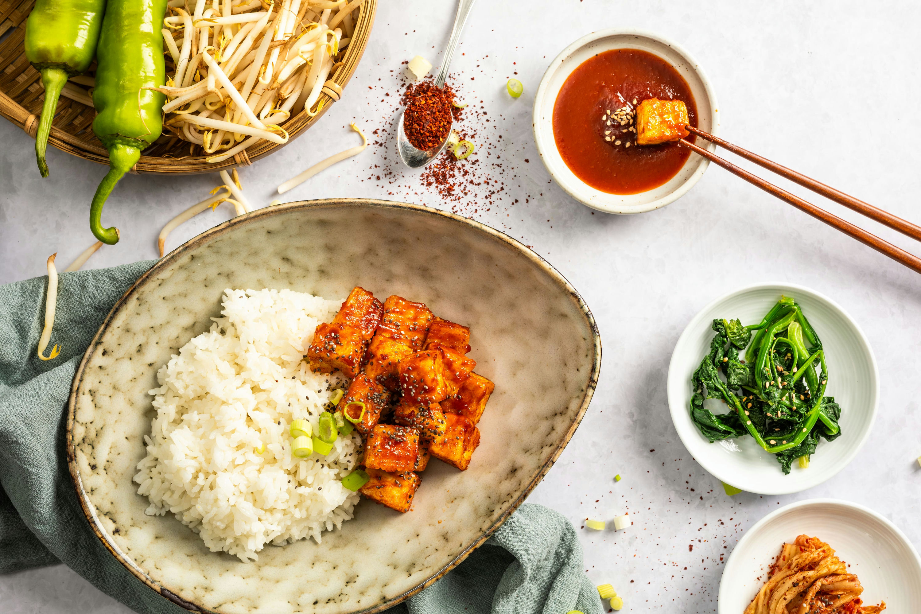 Reis, Tofu, Sojasprossen und eine rote Sauce schön hergerichtet auf einzelnen Tellern