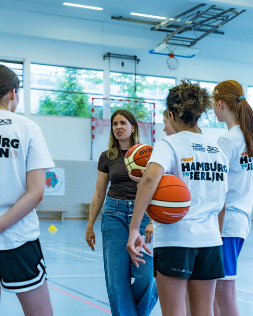 Basketball-Spielerinnen hören der Trainerin zu